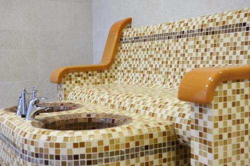 a tiled bathroom with a toilet with a sink at Ruskovets Thermal SPA & Ski Resort in Bansko