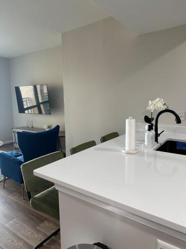 a kitchen with a white counter and blue chairs at Beautiful Arlington Apartment with Pool & Parking! in Arlington