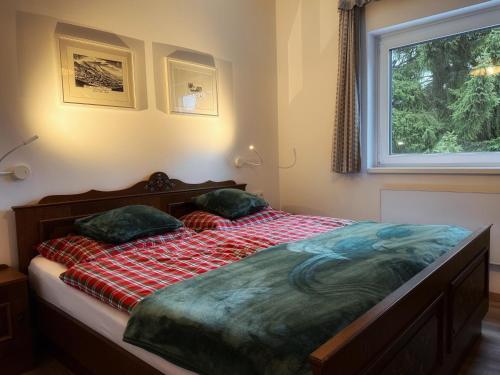 a bedroom with a bed with a red blanket and a window at Koralm Appartement 7 in Wolfsberg
