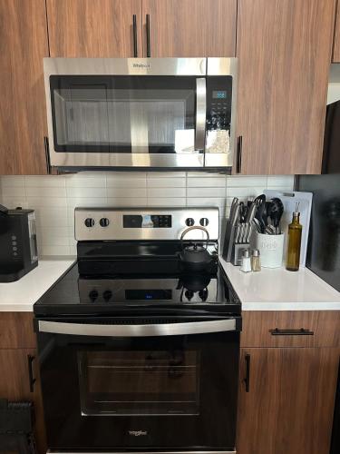 a kitchen with a black stove and a microwave at Beautiful Arlington Apartment with Pool & Parking! in Arlington