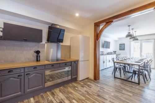 une cuisine et une salle à manger avec une table et des chaises dans l'établissement La suite Kora, à Tremblay-en-France