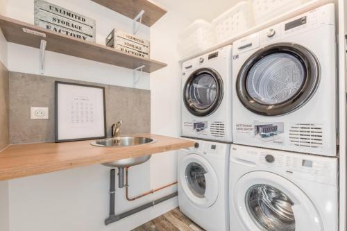 - une buanderie avec 2 lave-linge et un évier dans l'établissement La suite Kora, à Tremblay-en-France