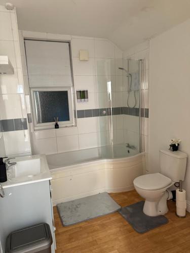 a bathroom with a tub and a toilet and a sink at 2 Bedroom House in Nottingham