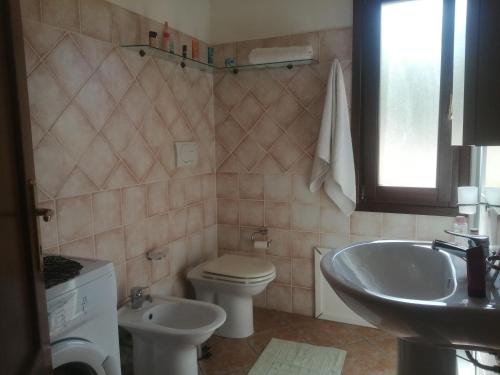 Un baño con un inodoro blanco y un lavabo. en Villetta Sardinia, en Costa Paradiso