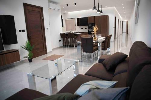a living room and kitchen with a couch and a table at Flat 3, nearby Beaches & Countryside, with Terrace in Mġarr