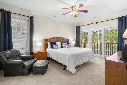 a bedroom with a bed and a chair and a ceiling fan at Pawleys Plantation Retreat Villa Deluxe Amenities in Pawleys Island