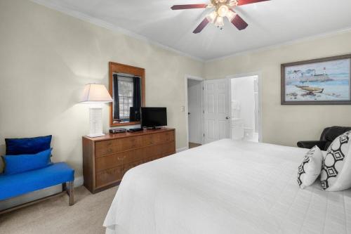 a bedroom with a white bed and a blue chair at Pawleys Plantation Retreat Villa Deluxe Amenities in Pawleys Island