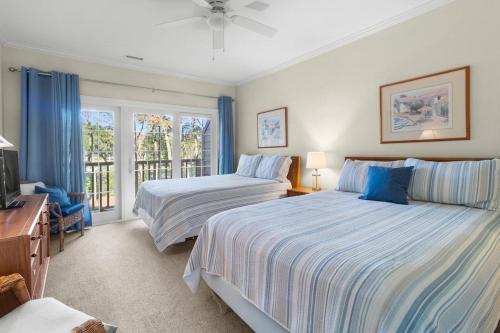a bedroom with two beds and a window at Pawleys Plantation Retreat Villa Deluxe Amenities in Pawleys Island
