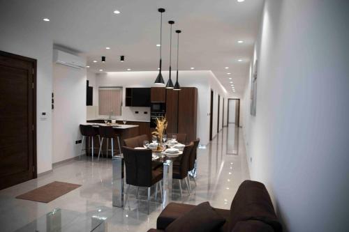 a dining room and kitchen with a table and chairs at Flat 3, nearby Beaches & Countryside, with Terrace in Mġarr