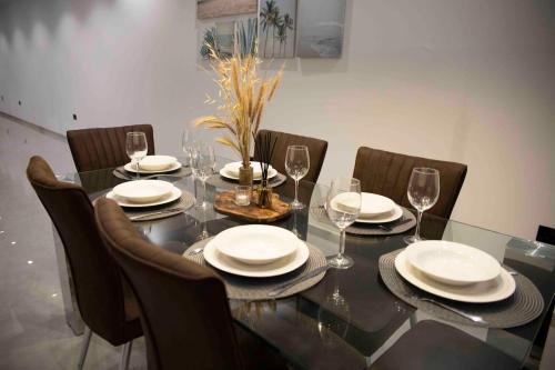 a dining table with chairs and plates and wine glasses at Flat 3, nearby Beaches & Countryside, with Terrace in Mġarr