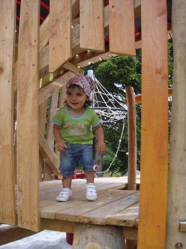 a little girl standing on a wooden platform at Schweizerhaus Swiss Quality Hotel in Maloja
