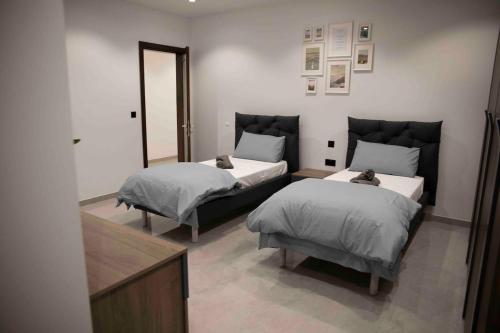 a bedroom with two beds and a mirror at Flat 3, nearby Beaches & Countryside, with Terrace in Mġarr