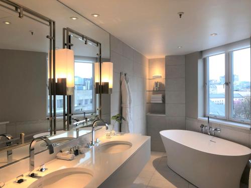 a bathroom with two sinks and a large mirror at Hotel Continental in Oslo
