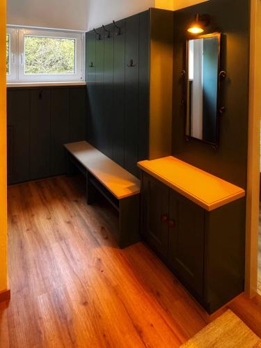 a room with a bench and a mirror and a window at Koralm Appartement 7 in Wolfsberg