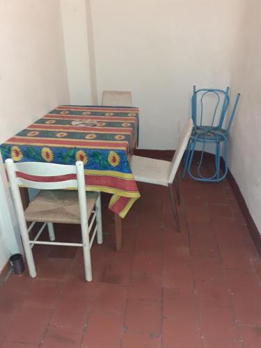 une table et des chaises dans une pièce avec une table, une table et des chaises dans l'établissement Dortoir pour hommes, à Béziers