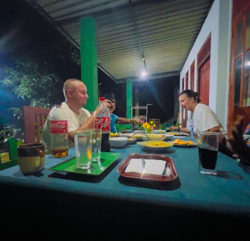 a group of people sitting at a table with food at Jm Resort in Dambulla