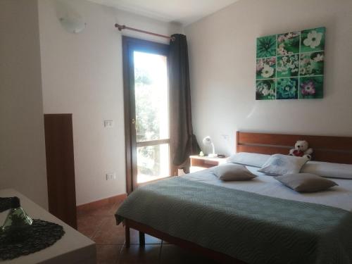 Un dormitorio con una cama grande y una ventana. en Villetta Sardinia, en Costa Paradiso