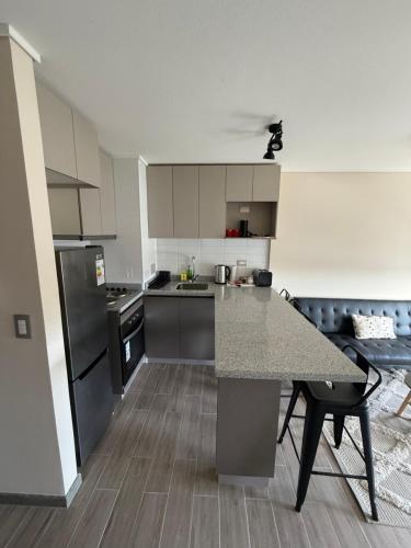 a kitchen with a granite counter top and stainless steel appliances at Depto Claudio 904 in Chillán