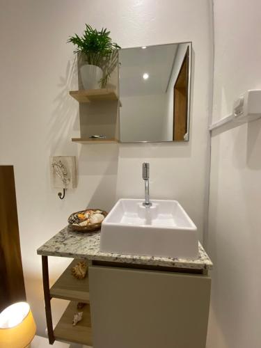 a bathroom with a white sink and a mirror at Hospedagem Tulipane - Praia do Campeche in Florianópolis