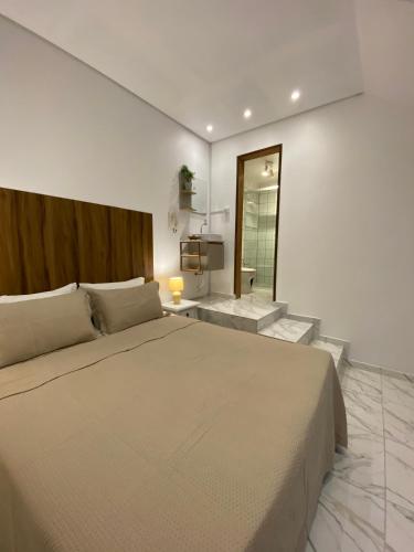 a bedroom with a large bed and a mirror at Hospedagem Tulipane - Praia do Campeche in Florianópolis