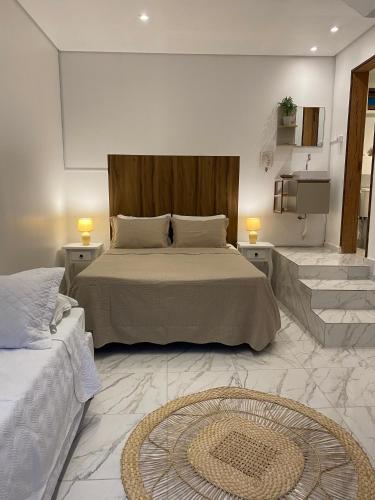 a bedroom with a bed with two tables and two lamps at Hospedagem Tulipane - Praia do Campeche in Florianópolis