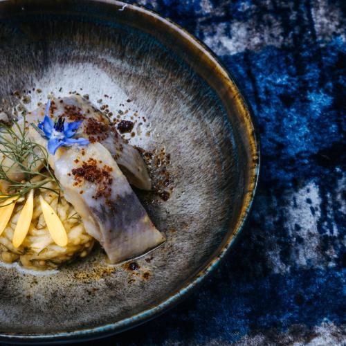 a bowl of food with a piece of fish on pasta at POSTEN nordic cuisine in Frederiksoord