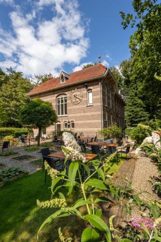 a building with a clock on the side of it at POSTEN nordic cuisine in Frederiksoord