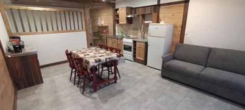 une cuisine avec une table, des chaises et un canapé dans l'établissement Studio au Grand Cœur Chaux, à Guyans-Vennes