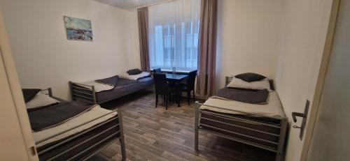 a room with three beds and a desk in it at Ferienwohnung in Krefeld Monteurzimmer Gästezimmer Messezimmer Apartment in Krefeld in Krefeld
