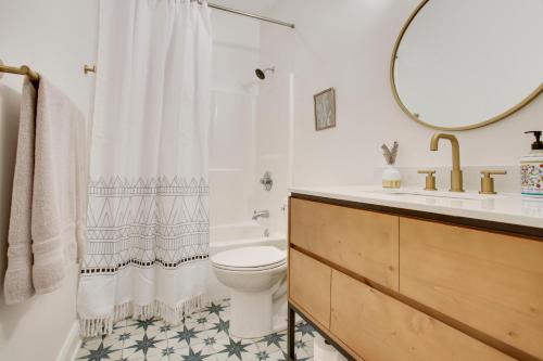 a bathroom with a toilet and a sink and a mirror at Lakefront NOLA Home with Hot Tub and Views! in New Orleans