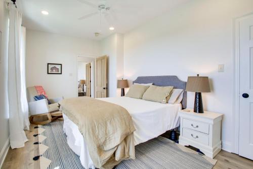 a white bedroom with a bed and a chair at Lakefront NOLA Home with Hot Tub and Views! in New Orleans