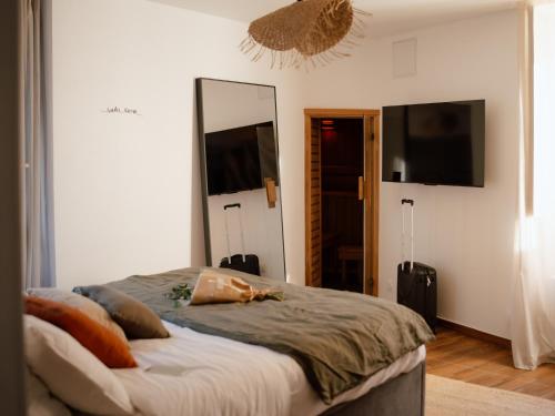 una camera da letto con un letto e un grande specchio di Suite Cara - Logement Atypique Sauna Balneo - Centre Historique a Brive-la-Gaillarde