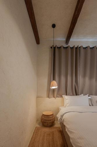 a bedroom with a bed and a lamp on a table at Serab Residencia, Boutique Hotel & Resort in Al Kaslīk