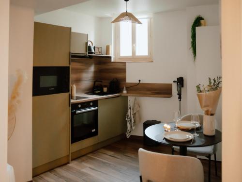 une petite cuisine avec une table et une salle à manger dans l'établissement Suite Cara - Logement Atypique Sauna Balneo - Centre Historique, à Brive-la-Gaillarde