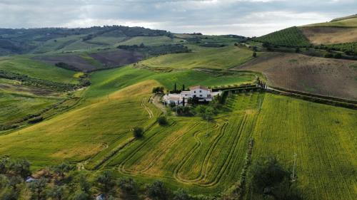 a house in the middle of a green field at Relais Casale Corvo in Guglionesi