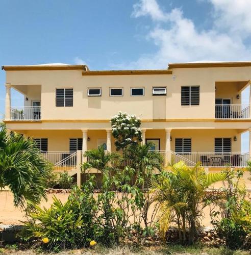 a building on the beach with trees in front of it at White Sands Anguilla Sand Unit in The Valley
