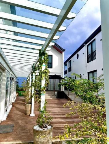 a patio with potted plants on a wooden deck at Natalna Boutique Home in Bacnotan