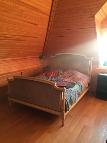un lit dans une chambre avec un mur en bois dans l'établissement Apt bord de mer, vue exceptionnelle,près Deauville, à Blonville-sur-Mer