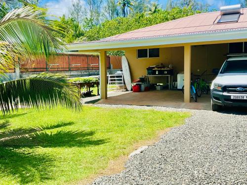 a house with a car parked in front of it at Tepoea Lodge in Fare