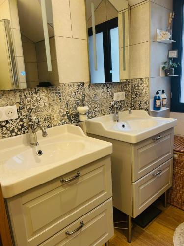 une salle de bain avec deux lavabos et un miroir dans l'établissement Maison centre ville Évian, à Évian-les-Bains