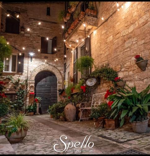 a stone building with a courtyard with potted plants at Il Sogno in Spello