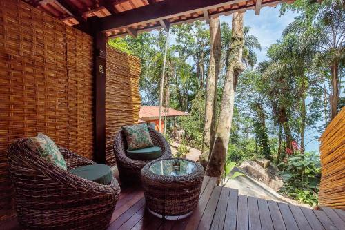 a porch with wicker chairs and a table on a deck at Pousada Lagamar in Praia Vermelha