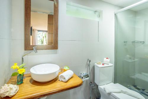 a bathroom with a sink and a toilet and a mirror at Pousada Lagamar in Praia Vermelha