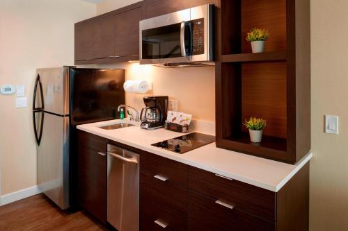 a kitchen with a sink and a refrigerator at TownePlace Suites by Marriott Grand Rapids Airport in Grand Rapids