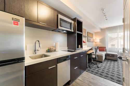a kitchen with a sink and a microwave at TownePlace Suites by Marriott Greensboro Coliseum Area in Greensboro
