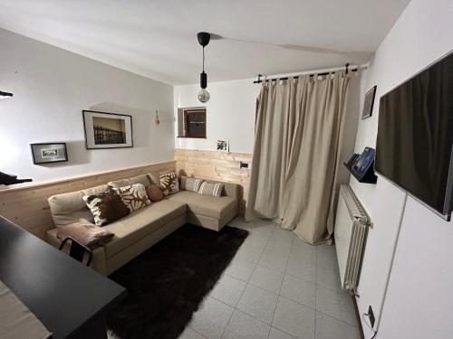 un soggiorno con un divano e una TV di *St. Bart* ad Aprica
