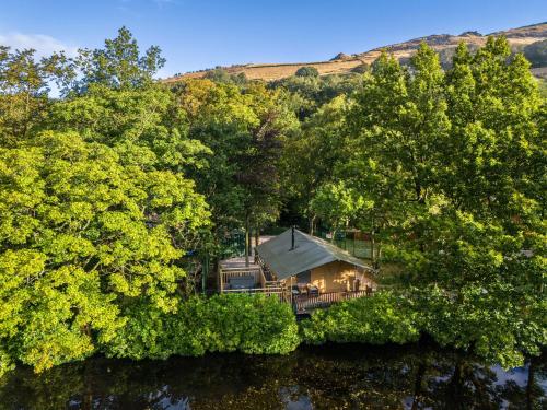 an aerial view of a house on the water with trees at Lakeside Pods - pets welcome in Oldham