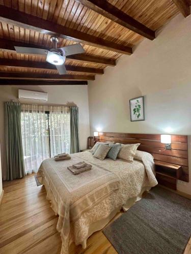 a bedroom with a large bed and a ceiling at Arasy in Puerto Iguazú