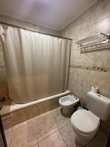 a bathroom with a toilet and a shower curtain at Arasy in Puerto Iguazú