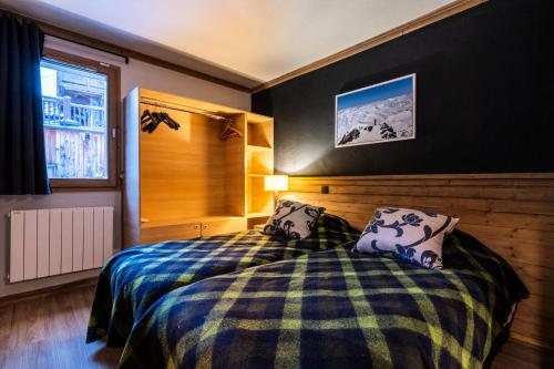 - une chambre dotée d'un lit avec une couverture et des oreillers dans l'établissement Chalet Mouflon - 4 Pièces pour 6 Personnes MAE-1791, à Val Thorens